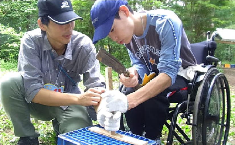 火おこしの指導を受けている様子