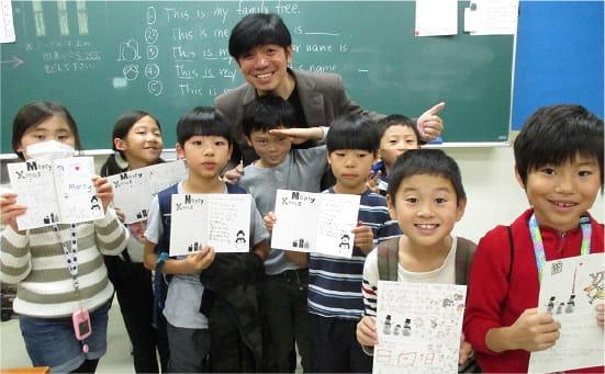 男性教師と子供達と記念撮影している様子