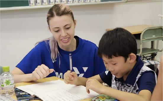 外国人女性が男の子と勉強を教えている様子