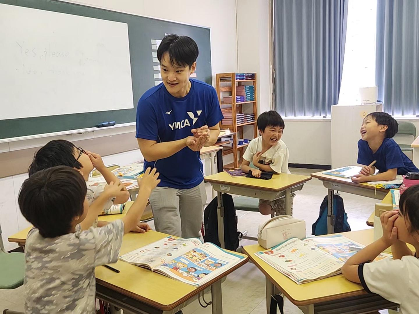 男性教師と子供達と記念撮影している様子